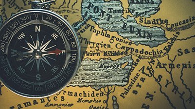 Ein runder Kompass liegt auf einer historischen Karte