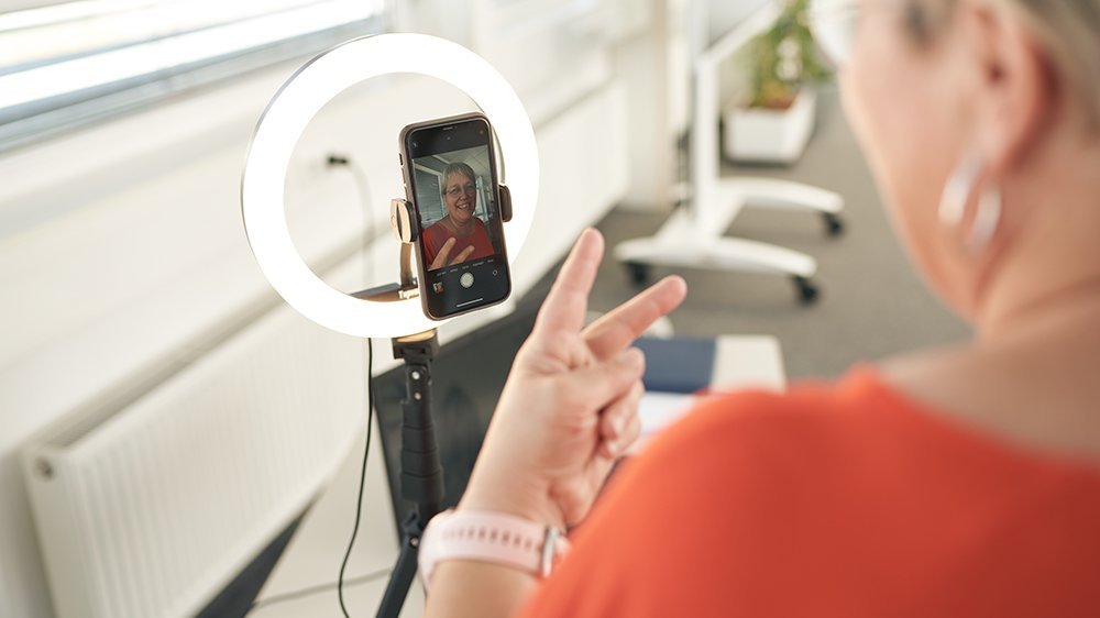 Eine Frau nimmt sich am Handy auf mit einem Ringlicht